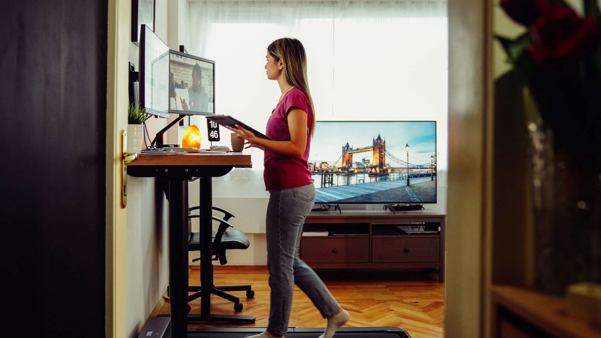 Person walking on under-desk treadmill while working at standing desk